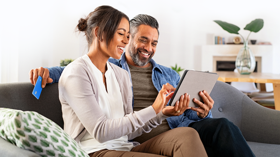 Couple smiling and looking into ipad