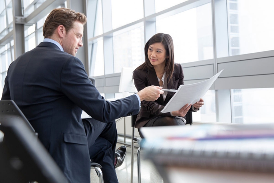 Professional man and woman looking at paperwork