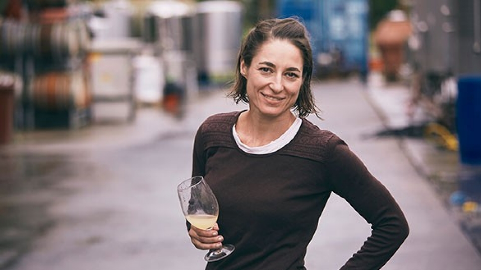 Octtava Wines owner Nikki Pulan holds a glass of wine and smiles to camera