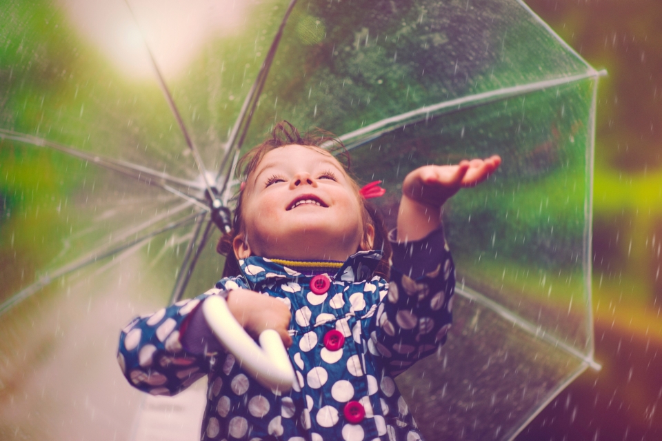 little girl holding an umbrella in the rain