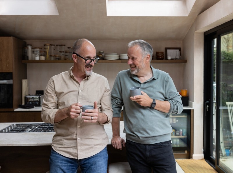 Two men drinking tea in kitchen