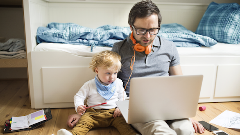 Man WFH on his laptop with kid