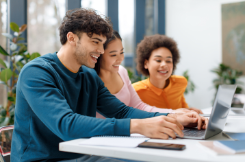 Young guy and two girls working on laptop
